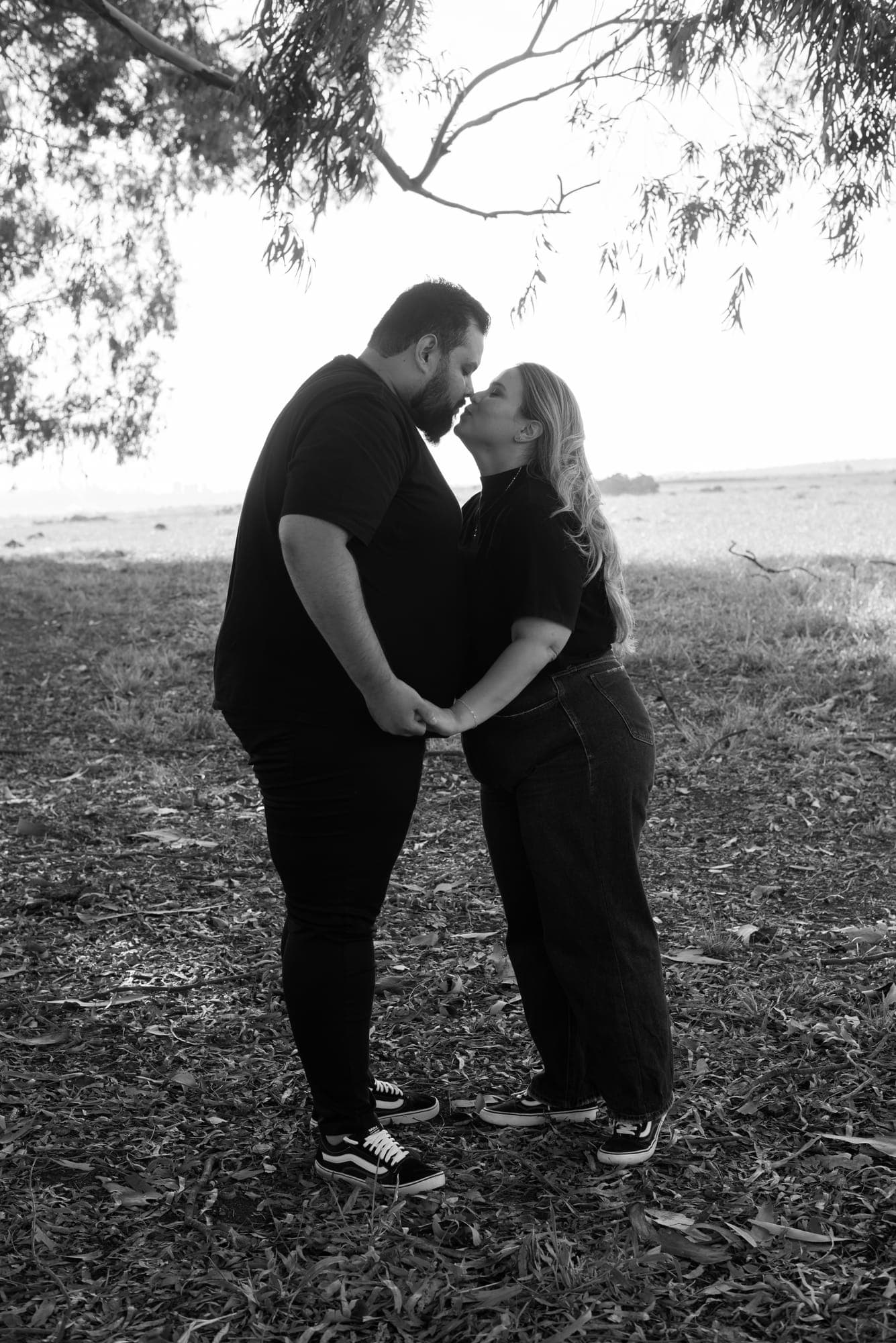 Nâmora e Lucas de mãos dadas, quase se beijando, em preto e branco